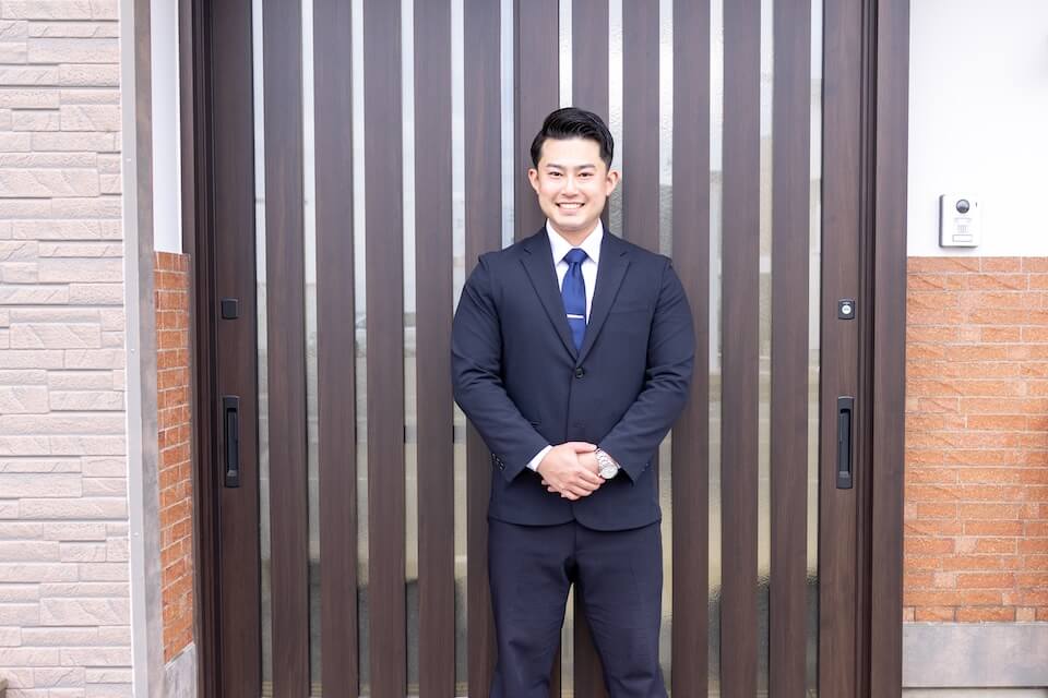 空き家の前で直接買取制度による即現金化を案内する天渡代表