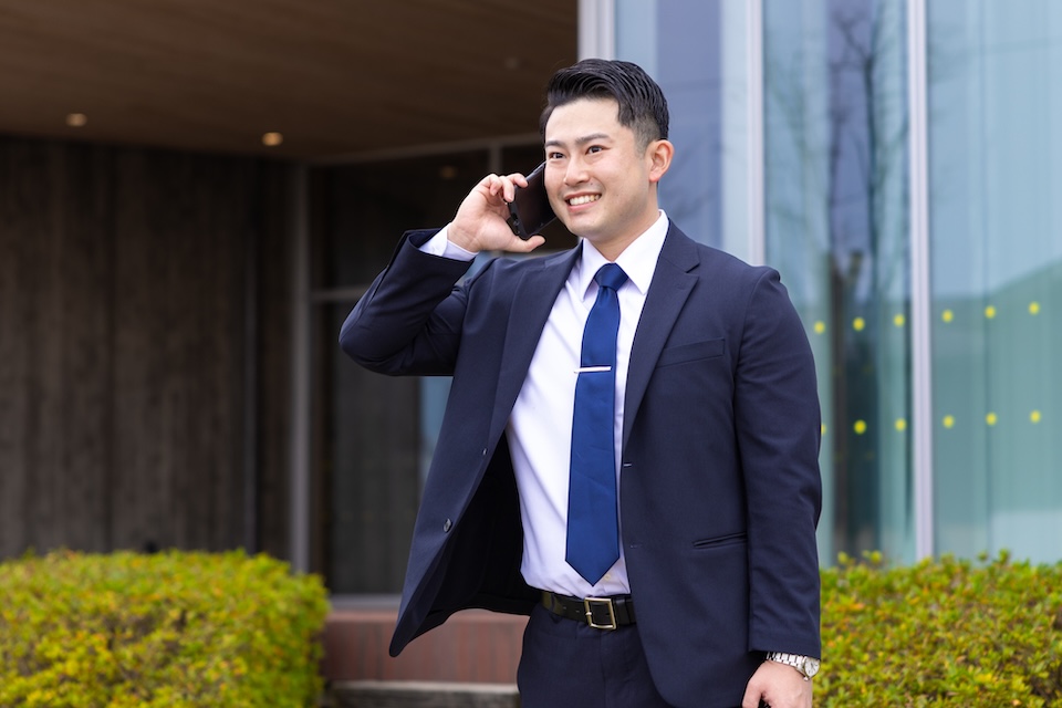 お客様と電話をする天渡代表